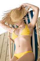Beach - woman with straw hat in yellow bikini