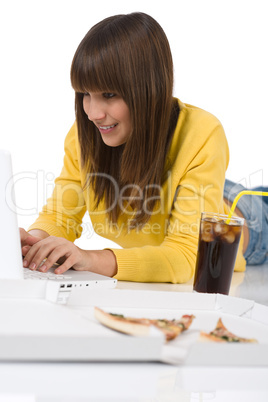 Happy female teenager with laptop lying down