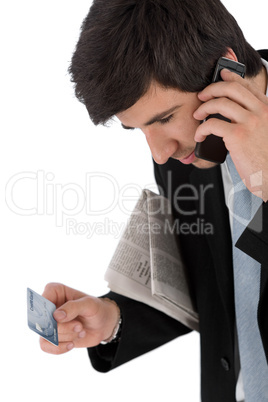 Young businessman holding mobile phone and credit card