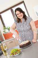 Happy plus size woman with chocolate cake and cream