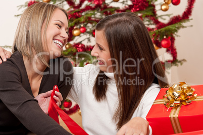 Two young women in front of Christmas tree