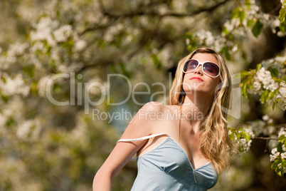 Spring - Young woman under blossom tree in orchard
