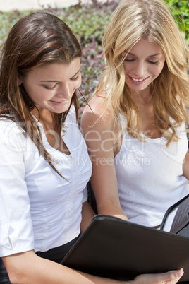 Two Young Businesswoman Outside Meeting Looking At Folder
