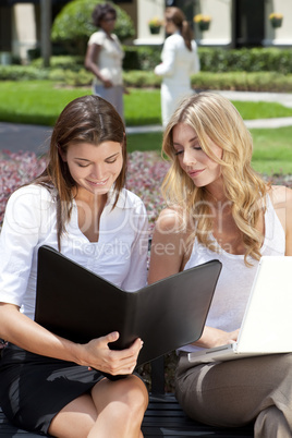Two Young Businesswoman Outside Meeting With Laptop & Folder