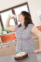 Plus size woman eat whipped cream in modern kitchen