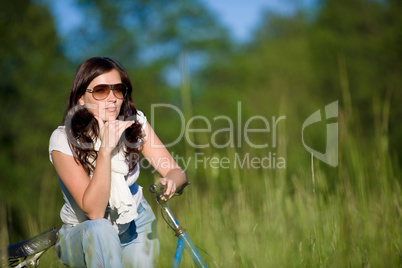 Woman with old-fashioned bike in summer meadow