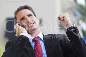 Male Executive Businessman Celebrating Success On Cell Phone