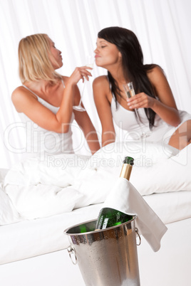 Two young women having fun in luxury hotel room