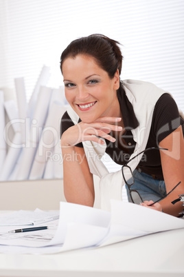 Young smiling female architect with plans