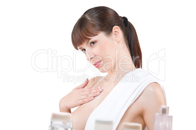 Body care: Young woman applying lotion in bathroom