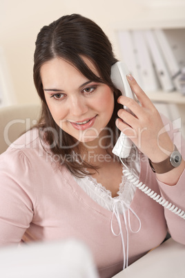 Portrait of young businesswoman on phone at office