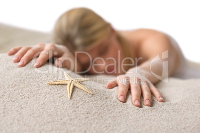 Beach - woman with starfish lying in sand