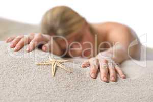 Beach - woman with starfish lying in sand