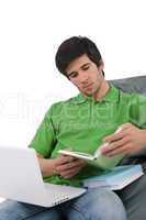 Student - Young man with laptop reading book