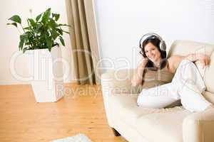 Woman with headphones listen to music  in lounge