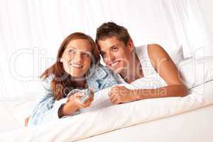 Young man and woman lying down in lounge