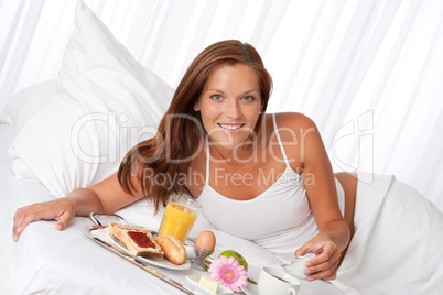 Young woman having breakfast in bed