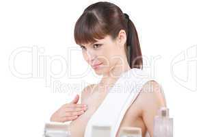 Body care: Young woman applying lotion in bathroom