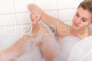 Body care series - Young woman shaving legs