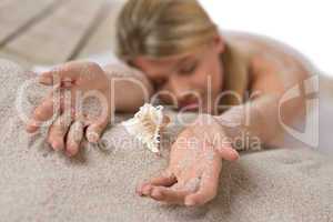 Beach - woman with shell lying in sand