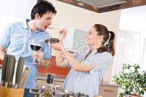 Happy couple cook in kitchen tasting food