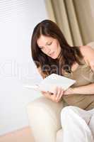 Young woman read book relaxing on sofa