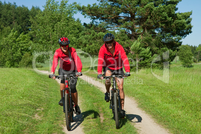 Young couple with mountine bike in spring nature