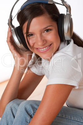 Smiling teenager with headphones listening to music