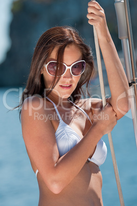 Beautiful woman on luxury yacht holding rope