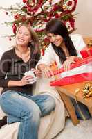 Two young woman wrapping Christmas present