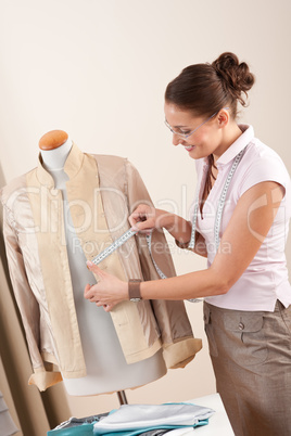 Female fashion designer taking measurement