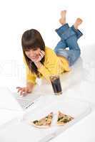 Happy female teenager with laptop and pizza