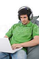 Young man with laptop and headphones sitting