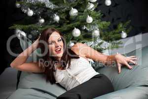 Provocative sexy woman posing in front of Christmas tree