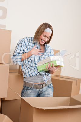Moving house: Woman unpacking box with book