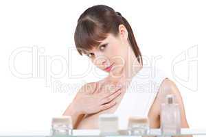 Body care: Young woman applying lotion in bathroom