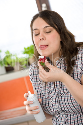 Plus size woman with whipped cream on strawberry licking lips