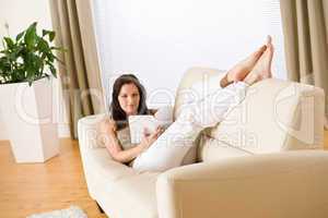 Young woman read book relaxing on sofa