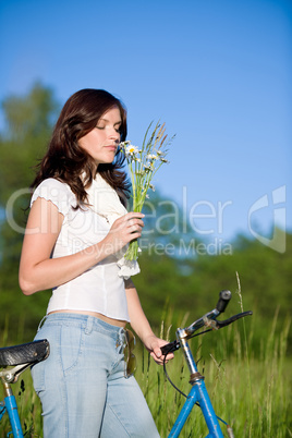 Woman with old-fashioned bike and summer flower