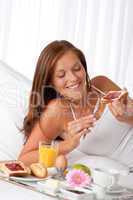 Young woman having breakfast in bed