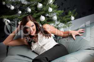 Provocative sexy woman posing in front of Christmas tree