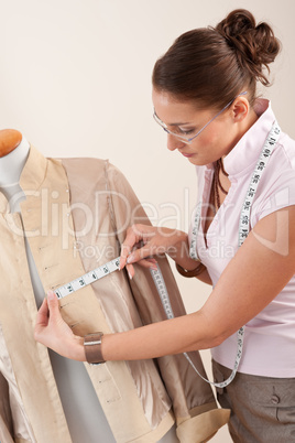 Female fashion designer taking measurement
