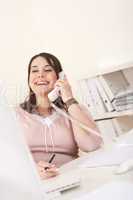 Smiling happy business woman on the phone at office