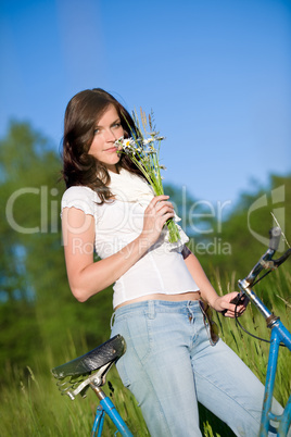 Woman with old-fashioned bike and summer flower