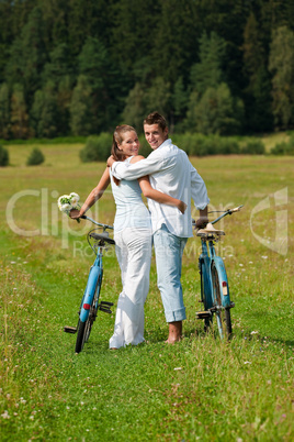 Romantic young couple with old bike in spring nature