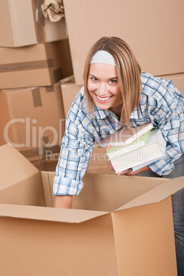 Moving house: Woman unpacking box with book