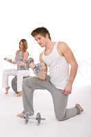Fitness - Young healthy couple exercise with metal weights