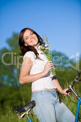 Woman with old-fashioned bike and summer flower