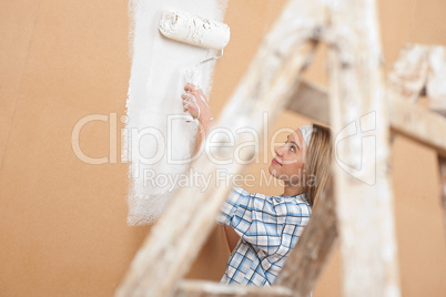 Home improvement: Woman painting wall with paint roller