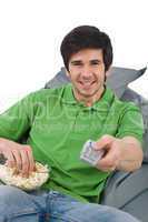 Young man holding remote control watch television